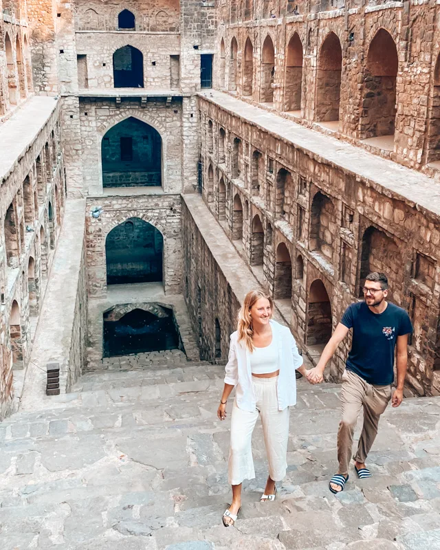 A couple walking hand in hand at Agrasen Ki Baoli​